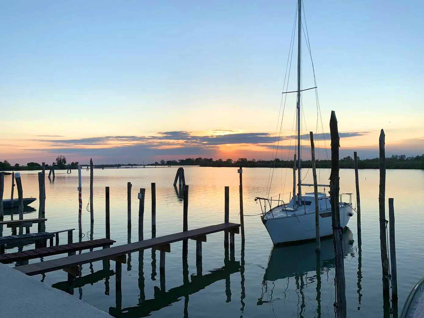 Tranquil harbor that cradles the sunset: Suite Jesolo offers boats and golden reflections for moments of relaxation that nourish the soul.