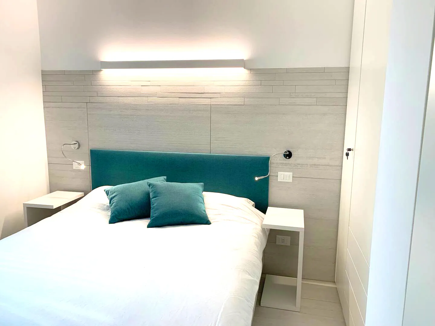 Comfort and perfect light in every instant: Suite Jesolo pampers you with an elegant bed and functional nightstands where relaxation and practicality embrace.